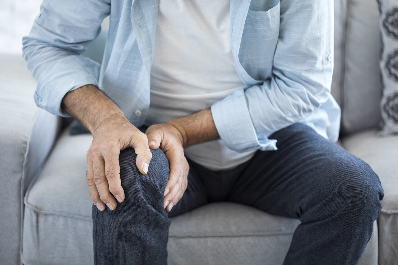 Man clutching his knee in pain